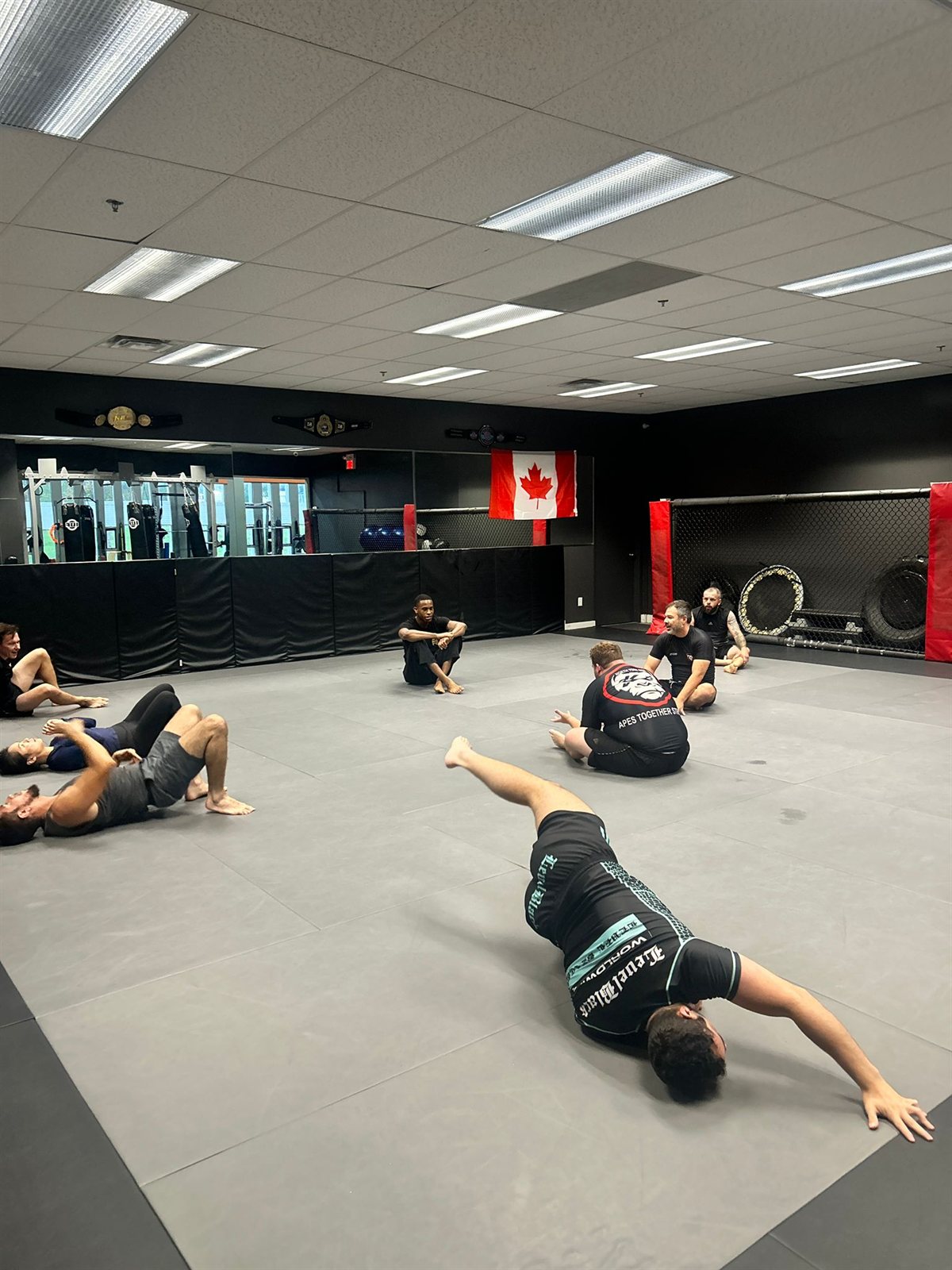 Students warming up together on the mats before jiu-jitsu class
